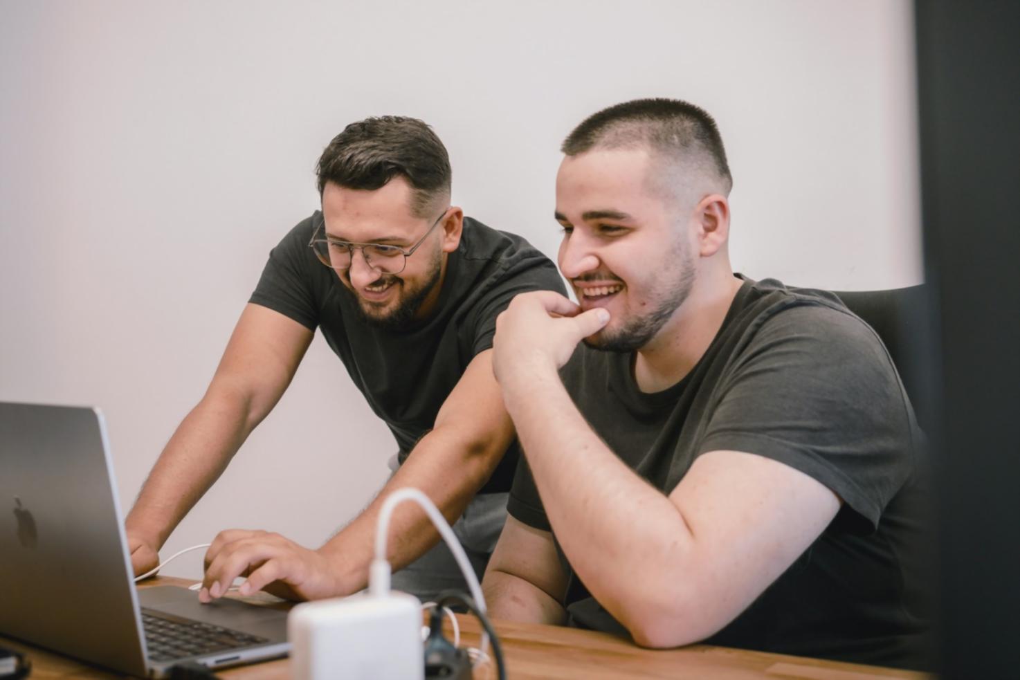 Persona analizando gráficos financieros en ordenador portátil con calculadora y documentos